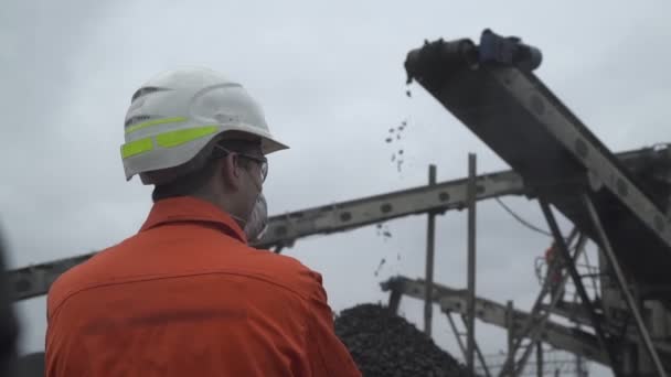Una vista posterior de un minero de carbón observando el proceso de minería del carbón — Vídeos de Stock