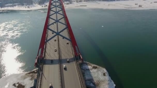 Drone disparó una cámara 4k volando por encima del puente colgante. coches de tráfico que cruzan la carretera sobre el río azul . — Vídeo de stock