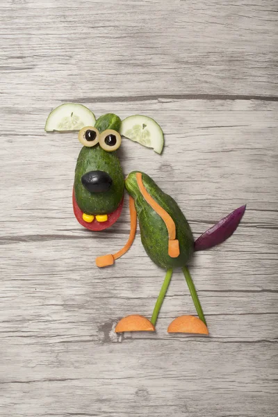 Funny dog made with cucumber on wooden background