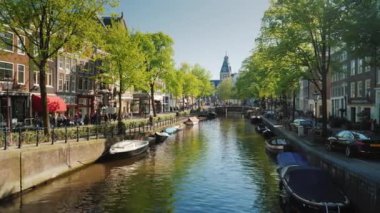 Amesterdam, Hollanda, Mayıs 2018: Amsterdam pitoresk kanalda. Tekne park edilmiş Bisiklet ve sahil boyunca.