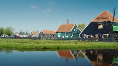 Zaanse Schans'a, Hollanda, Mayıs 2018: Pan vurdu: Hollanda - Zaanse Schans'a pitoresk eski köy. Evler su turist dar sokaklarında yürüyüş yansıtılır