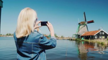 Genç bir kadın eski yel değirmenleri Hollanda Fotoğraf çekme. Avrupa ve Hollanda kavramı seyahat