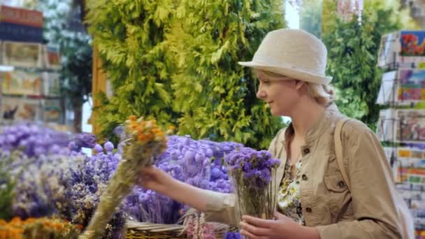 Turista mujer selecciona un ramo de flores en un famoso mercado de flores en el centro de Amsterdam — Vídeo de stock