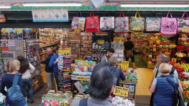 Amesterdam, Países Bajos, mayo de 2018: Los visitantes eligen flores y recuerdos en el famoso mercado de flores de Ámsterdam . — Vídeo de stock