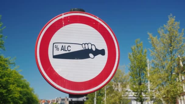 Kamuya açık bir yerde alkol tüketimi yasaklayan bir trafik işareti. Bir şişe alkol beyaz bir arka plan üzerinde kırmızı bir daire daire içine alınmış — Stok video