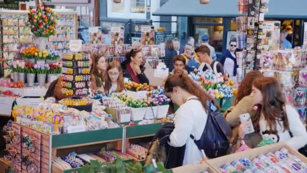 Amesterdam, Pays-Bas, mai 2018 : Les touristes choisissent des souvenirs et des fleurs sur le marché aux fleurs populaire à Amsterdam — Video