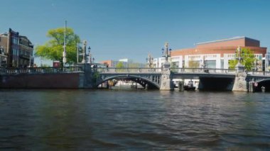 Amesterdam, Hollanda, Mayıs 2018: Amsterdam kanalları aracılığıyla seyir. Opera ve Bale Tiyatrosu yapı geçmiş yüzmek