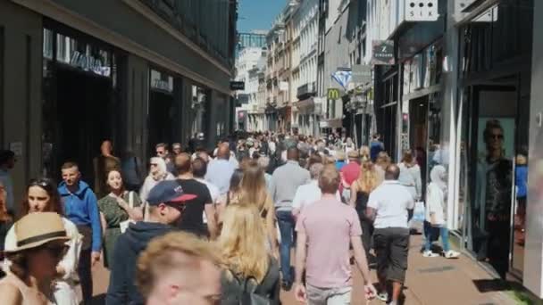 Amesterdam, Niederlande, Mai 2018: eine lebhafte Straße mit vielen Geschäften, Cafés und Boutiquen. Eine Menge Touristen geht mit. Tourismus im Konzept der Niederlande — Stockvideo