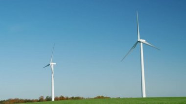 Yeşil çayır üzerinde iki rüzgar türbinleri. Alternatif enerji kaynakları