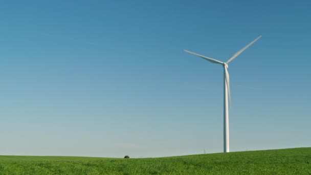 Een industriële windgenerator op een groene heuvel. Alternatieve bronnen van schone energie. 4k 10 bit video — Stockvideo