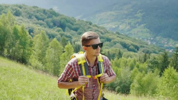 Um turista muito cansado com uma mochila sobe o caminho da montanha. Força de vontade e resistência física — Vídeo de Stock