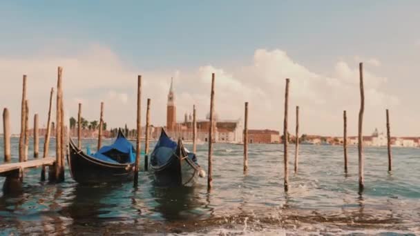 Avond voor zonsondergang in Venetië. Een paar gondels rock op de golven, er zijn geen mensen — Stockvideo