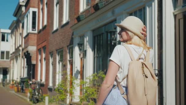 Uma jovem mulher admira a arquitetura antiga na rua estreita da cidade europeia . — Vídeo de Stock
