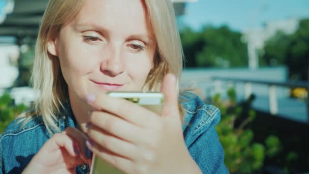 Retrato de uma mulher com smartphone. Relaxe no terraço de verão no café — Vídeo de Stock