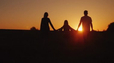 Üç kişilik bir aile ileri gün batımında gider