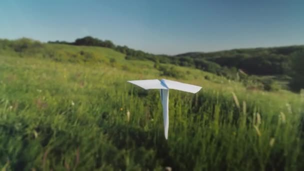 Un avión de papel real está volando sobre un pintoresco valle. Seguir tiro — Vídeos de Stock