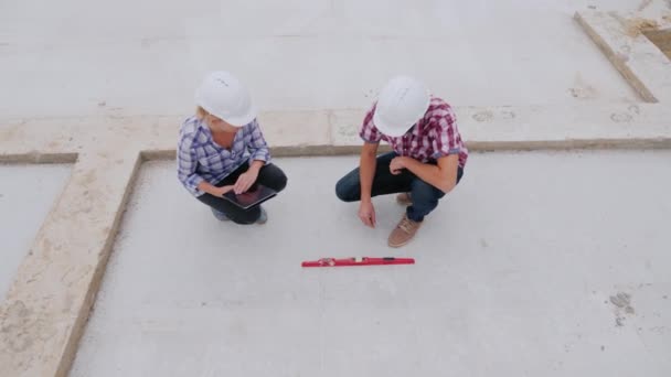 Engineers check the accuracy of building construction. Use the level and the tablet. Top view — Stock Video
