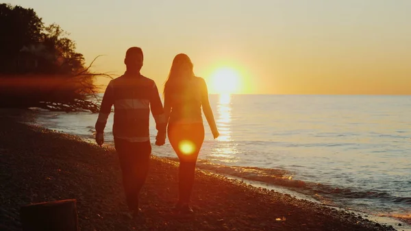 Steadicam tiro: jovem casal multi-étnico de mãos dadas, andando ao longo da praia ao pôr do sol. Homem asiático e mulher caucasiana — Fotografia de Stock