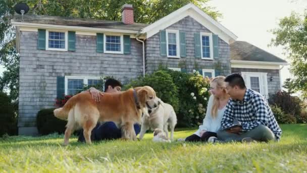 Egy többnemzetiségű baráti játszik a kutyák a kertben, a ház — Stock videók