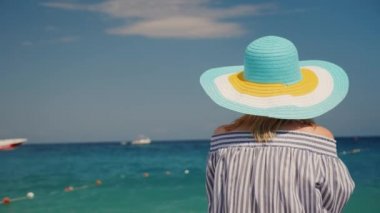 Şapkalı bir kadın denizin bir dikiz hayran. Kadın tatil kavramı