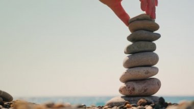 Denizin arka planına karşı çakıl taşlarından bir kule inşa et. Denge ve meditasyon kavramı