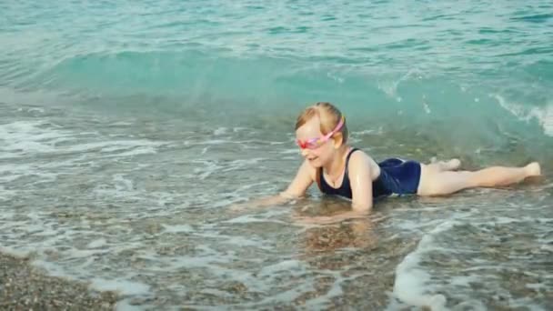 Блондинка в купальнику розважається на хвилях моря — стокове відео