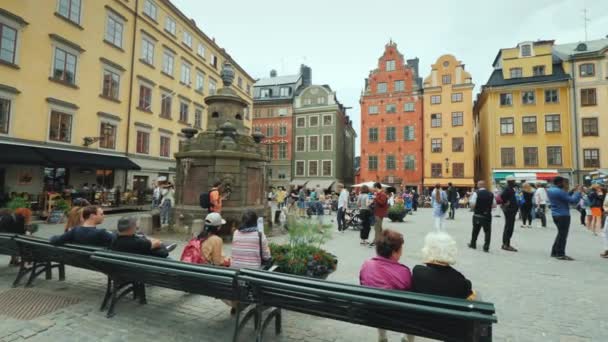 Stockholm, schweden, juli 2018: der platz der altstadt im zentrum von gamla stan. schöner Brunnen in der Mitte des Hintergrundes von erkennbar farbigen Häusern — Stockvideo