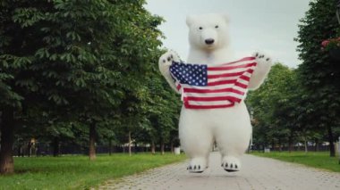 Bir kutup ayısı şeklinde bir büyük büyüme bebek eğlenceli ve Şehir Parkı içinde büyük bir Amerikan bayrağı sallayarak atlar