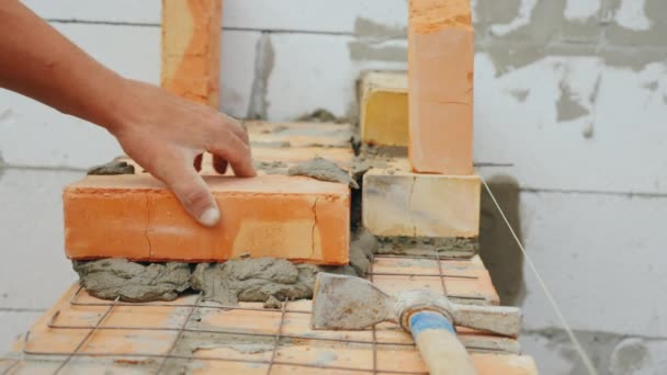 Μια επαγγελματική εργαζόμενος βάζει το τούβλο στην πλινθοδομή — Αρχείο Βίντεο