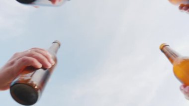 Bir grup arkadaşıyla tıklatması gözlük bira şişeleri gökyüzü, alt kamera açısı ile
