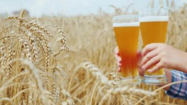 İki bardak buğday alan arka planı baştan çıkarıcı soğuk bira. Tanınmayan bir kadın elinde