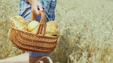 Fırından yeni çıkmış bir çevre dostu kendi tahıl üretimi buğday unundan yapılmış ekmek hasır sepet içinde bir genç kadın çiftçi taşır