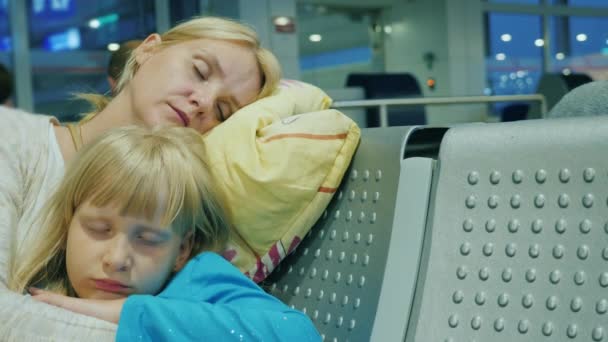 Mulher cansada com uma criança dorme no terminal do aeroporto. Atraso ou cancelamento do conceito de viagem — Vídeo de Stock