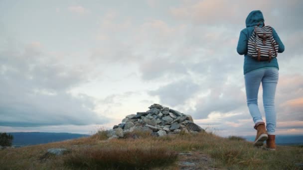 O viajante ascende ao topo da montanha onde se encontra um pequeno monte. A dura natureza da Noruega — Vídeo de Stock