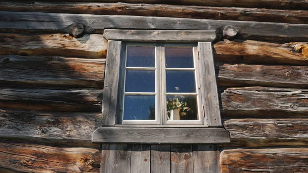 Okno s květinami na parapetu ve starém dřevěném domě — Stock fotografie