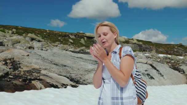 Mujer feliz jugando bolas de nieve en un glaciar en Noruega. El verano caluroso, pero la nieve no se ha derretido todavía - la naturaleza asombrosa de Escandinavia — Vídeos de Stock