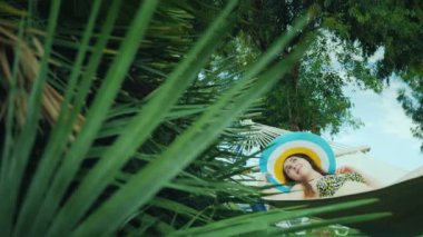 Medeniyet uzak, Genç bir kadın bir hamak rahatlatır. Yeşil palmiye ağaçları saran, mavi gökyüzü