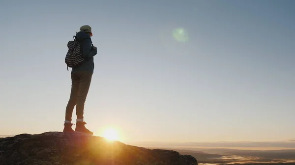Снимок журавля: Женщина-путешественница стоит на вершине горы, смотрит на красивый пейзаж впереди, восхищается природой Норвегии — стоковое фото