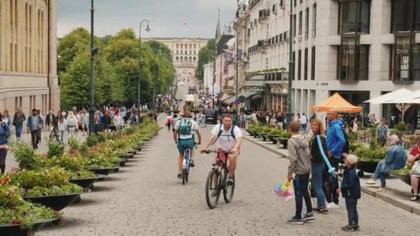 Oslo, Norvegia, luglio 2018: Street life in Oslo - A view along the Karl Johans Street towards the Royal Palace. Una strada bella e trafficata con molti caffè e negozi — Video Stock