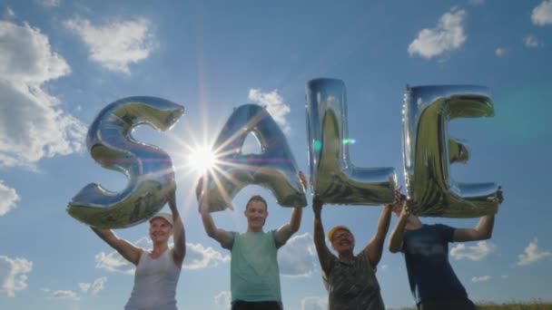 Mehrere Personen halten Luftballons mit dem Wort Verkauf in der Hand — Stockvideo
