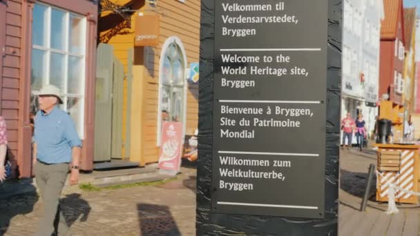 Bergen, Noruega, julio 2018: Stella con la insignia de la UNESCO en Bergen. En el fondo, viejas casas de madera — Vídeos de Stock