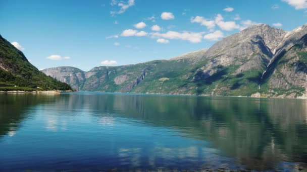 En vacker fjord i Norge, bergen reflekteras i vattnet. Visa från fönstret i bussen — Stockvideo