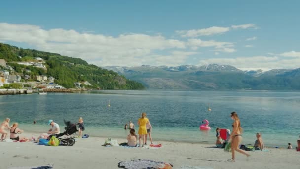 Oystesse, Норвегія, Липень 2018: Туристів купання і відпочиваючи на маленькому пляжі посеред мальовничих фіорд — стокове відео