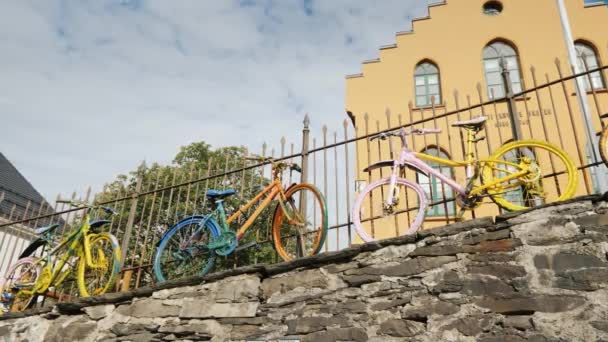 Bergen, Noruega, Jule 2018: Varias bicicletas de colores están en la valla. Decoración original en la ciudad — Vídeos de Stock