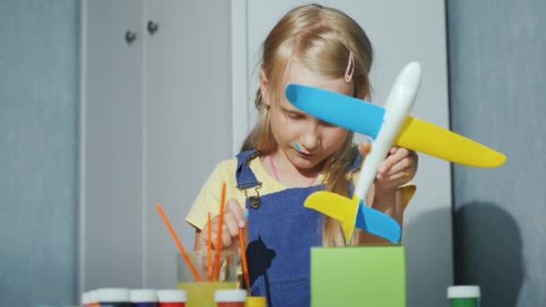 Cooles Mädchen bemalt ein Spielzeugflugzeug. Lernspiele für Kinder — Stockvideo