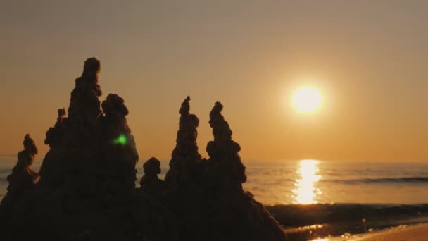 Un château de sable au bord de la mer au coucher du soleil — Video