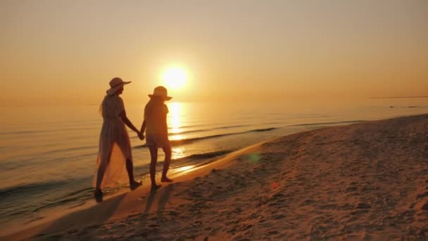 Anya és lánya séta a tengerparton naplementekor. Nyaralás egy gyermek koncepció — Stock videók