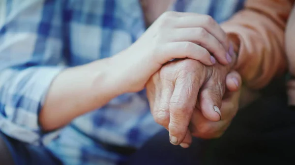 女性は彼女の手で彼女の高齢の祖母の手を保持します。 — ストック写真