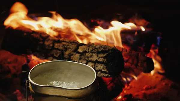 La bouilloire bouillonne autour du feu. Préparation de thé chaud et de nourriture lors d'une randonnée — Photo