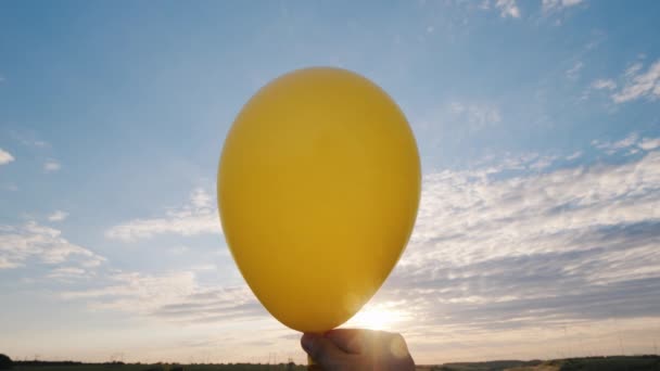 Levegő jön a sárga hőlégballon és bénán válik. A kék ég háttér — Stock videók